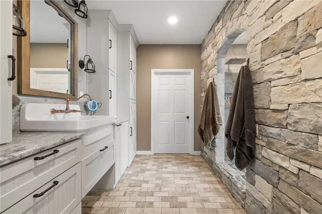 a bathroom with a granite countertop sink and a mirror