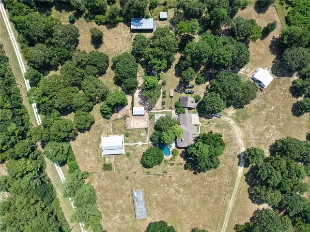 an aerial view of a house with a yard and greenery