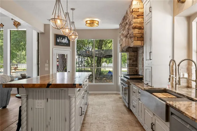 a kitchen with granite countertop a sink and a stove