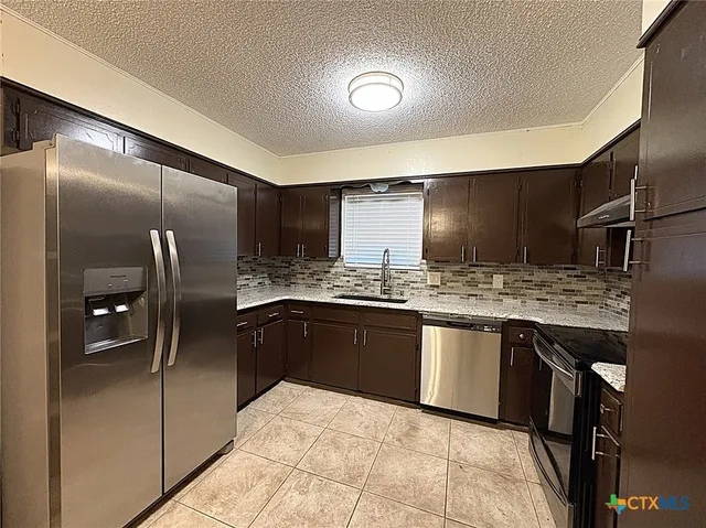 a kitchen with stainless steel appliances granite countertop a sink and cabinets