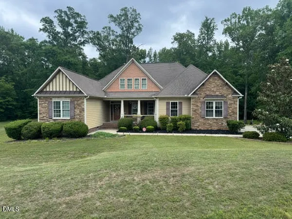 a front view of a house with a yard and green space