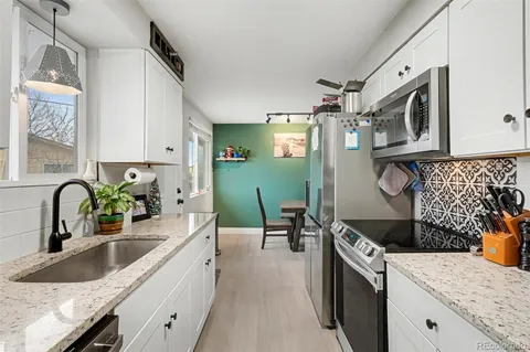 a kitchen with granite countertop a sink stove and cabinets