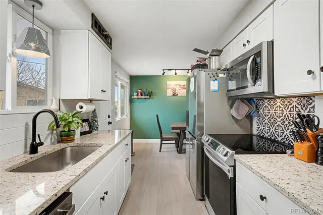 a kitchen with granite countertop a sink stove and cabinets