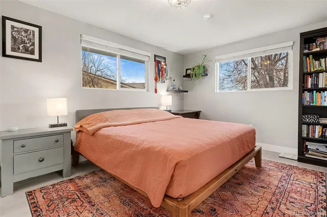 a bedroom with a bed and painting on the wall
