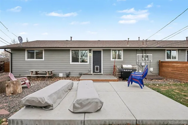 a view of a patio with table and chairs with wooden fence