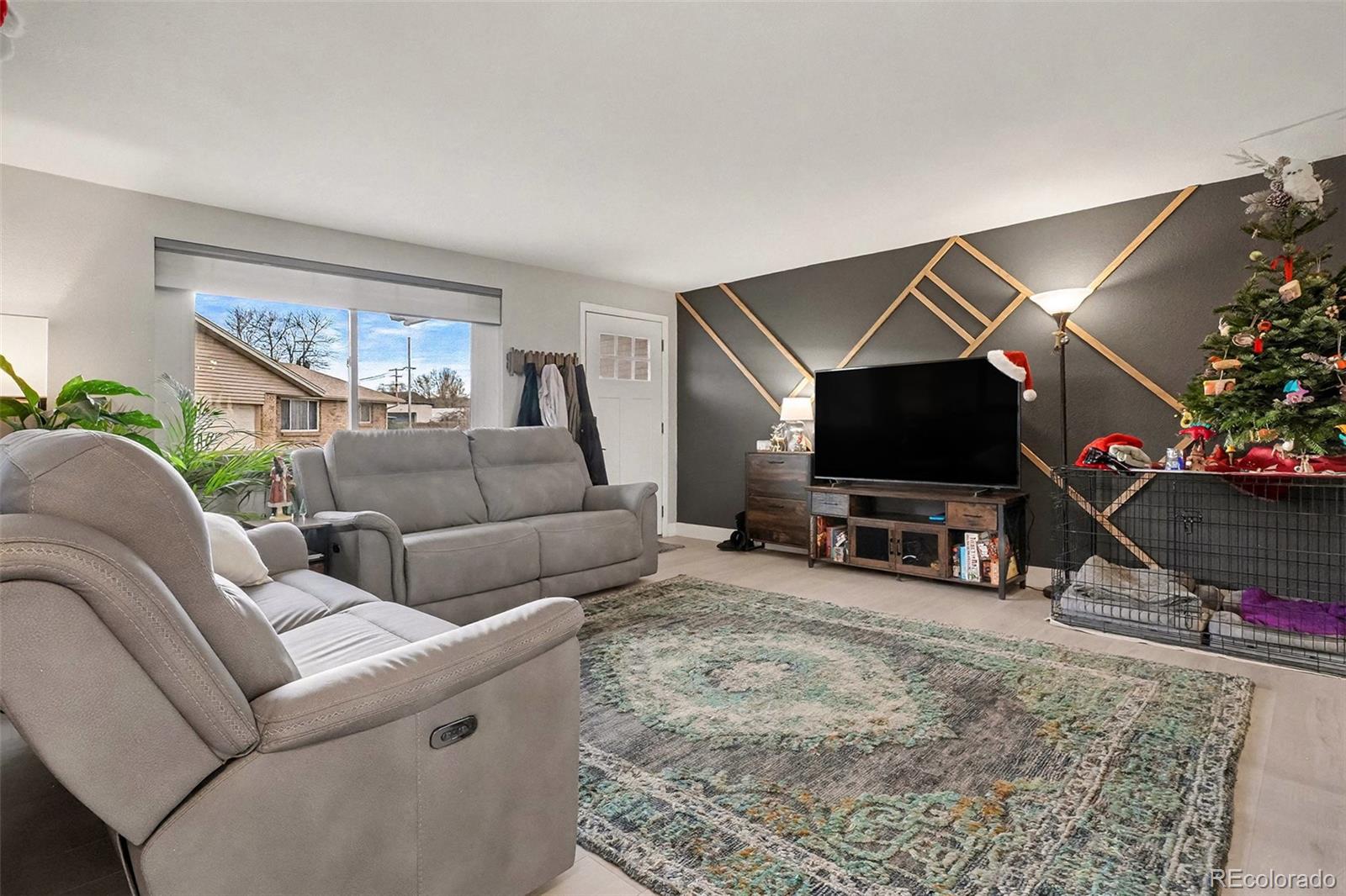 4784 Swadley Street Wheat Ridge, CO 80033 - Photo 5 of 22 a living room with furniture and a flat screen tv