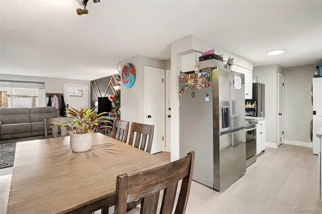 a kitchen view with stainless steel appliances furniture refrigerator and dining table