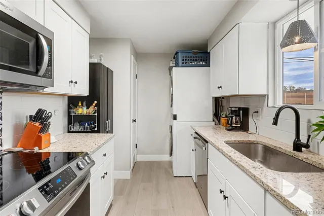 a kitchen with stainless steel appliances granite countertop a sink and a stove