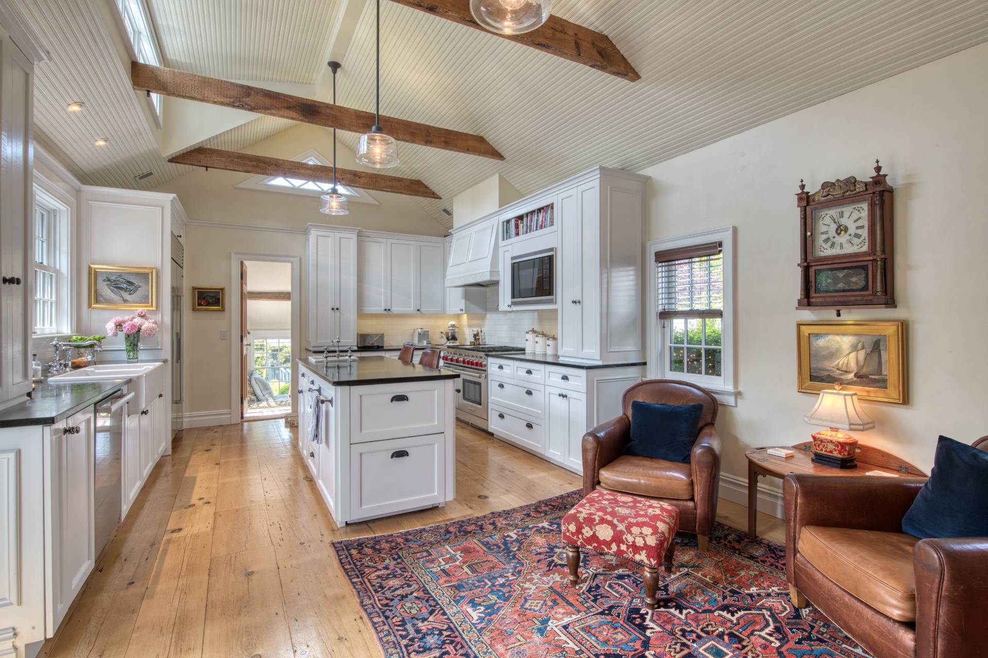 23 Howard Street Sag Harbor, NY 11963 - Photo 3 of 14 a kitchen with stainless steel appliances granite countertop a stove top oven a sink a dining table and chairs with wooden floor