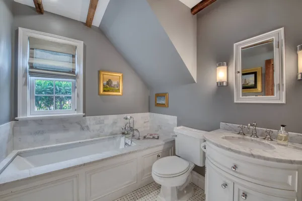 a bathroom with a granite countertop sink mirror vanity and toilet