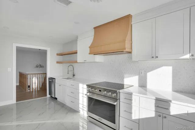 a kitchen with stainless steel appliances granite countertop a stove and a white cabinets