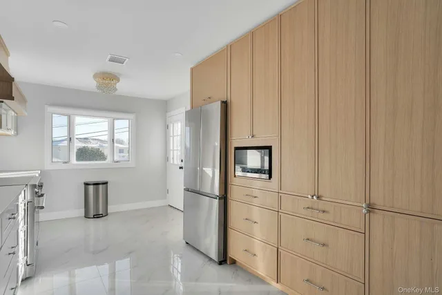 a kitchen with white cabinets and refrigerator