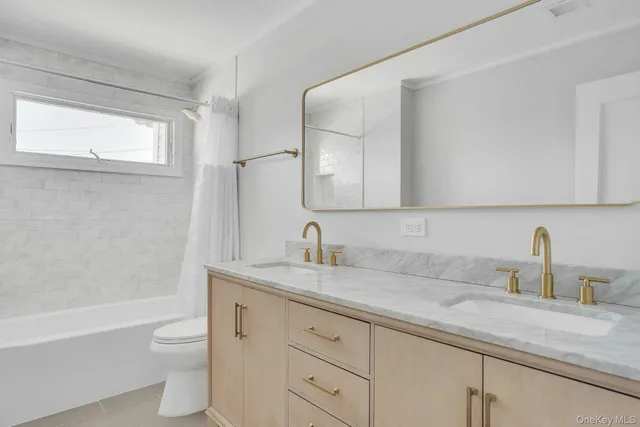 a bathroom with a granite countertop sink a toilet and a bathtub