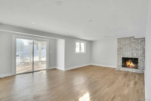 wooden floor fireplace and windows in an empty room