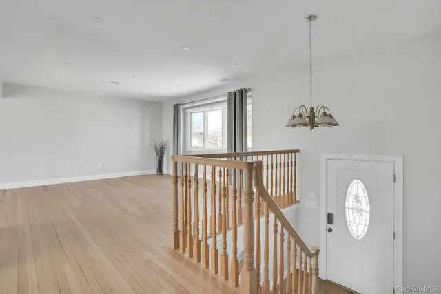 a view of a hallway with wooden floor and windows