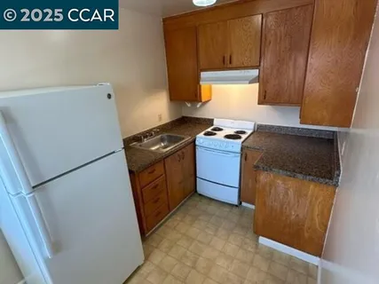 a kitchen with a refrigerator stove and cabinets