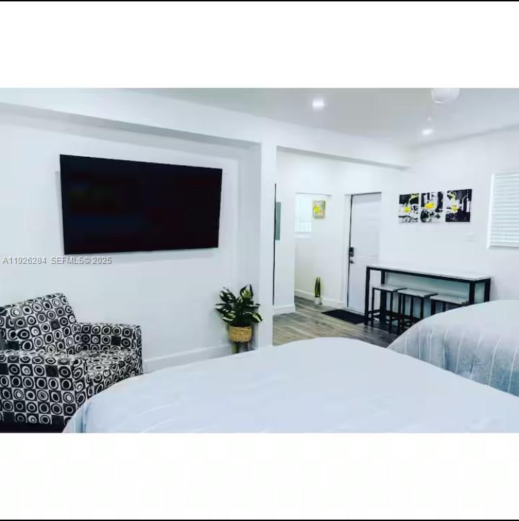 1352 Northwest 52nd Street, Unit B Miami, FL 33142 - Photo 2 of 9 a living room with furniture and a flat screen tv