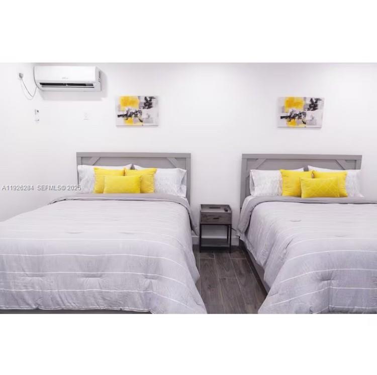 1352 Northwest 52nd Street, Unit B Miami, FL 33142 - Photo 3 of 9 a bedroom with a bed and painting on the wall