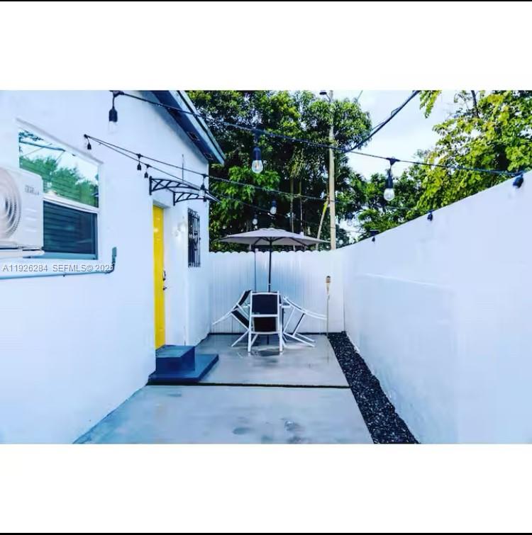 1352 Northwest 52nd Street, Unit B Miami, FL 33142 - Photo 9 of 9 a chair and table sitting in backyard of a house