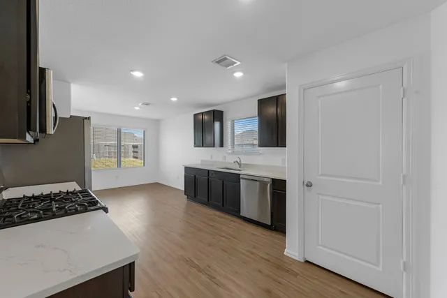 a large kitchen with a stove and a refrigerator