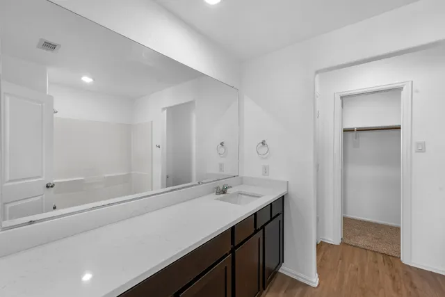 a bathroom with a shower sink and mirror