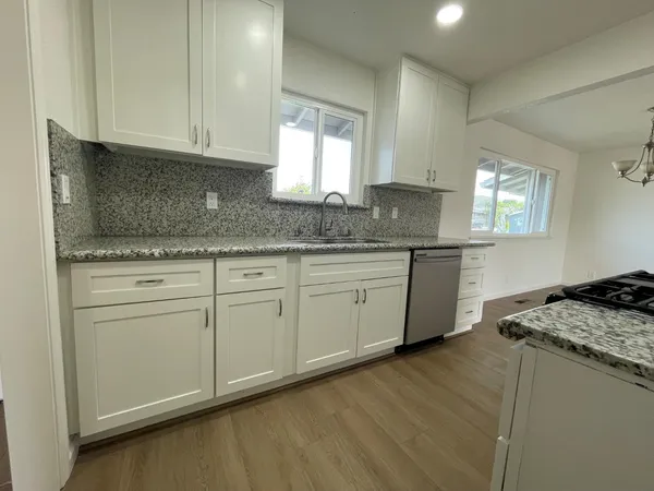 a kitchen with granite countertop cabinets stainless steel appliances a sink and a window