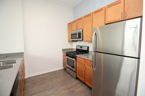 a white refrigerator freezer and a stove sitting inside of a kitchen