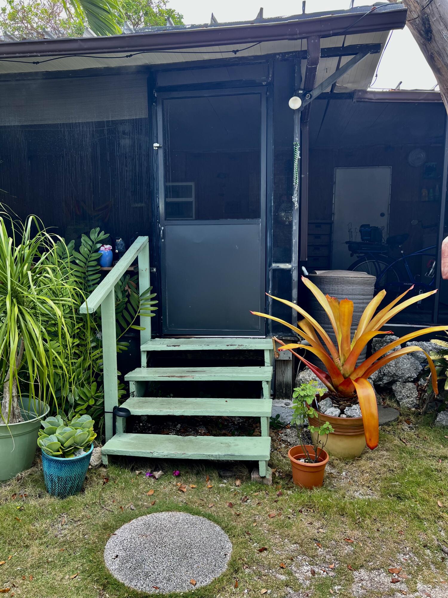 702 Largo Road Key Largo, FL 33037 - Photo 3 of 19 a backyard of a house with barbeque oven table and chairs