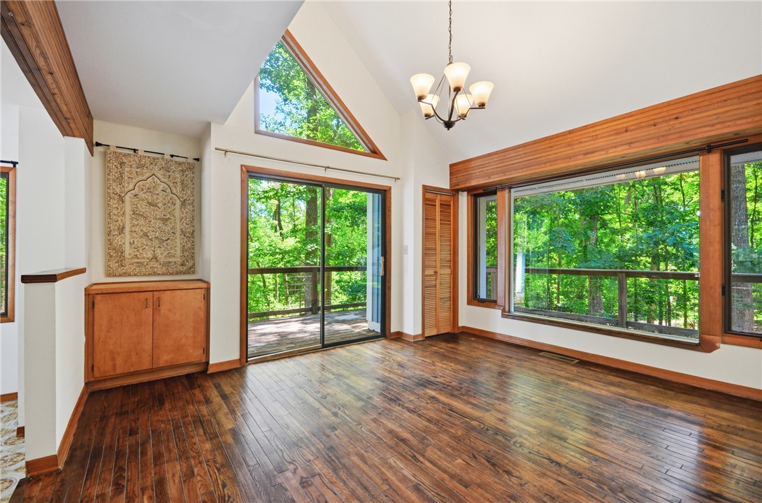 1298 Carradine Road Seneca, SC 29678 - Photo 7 of 43 A spacious room with soaring ceilings and rich wood flooring opens to a wraparound deck.