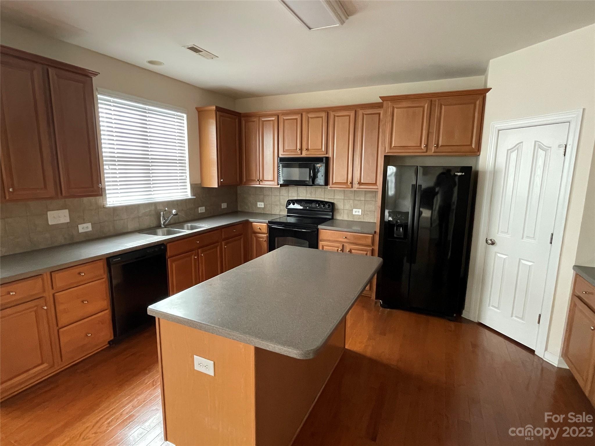 6405 Baltray Road Charlotte, NC 28278 - Photo 2 of 14 a kitchen with a refrigerator a sink a stove a microwave and island