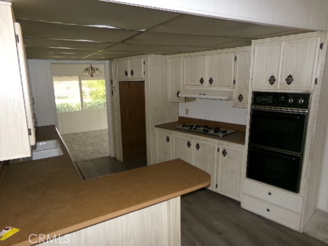 324 Ridgecrest Parkway Oroville, CA 95966 - Photo 17 of 33 a kitchen with granite countertop a refrigerator a sink and white cabinets