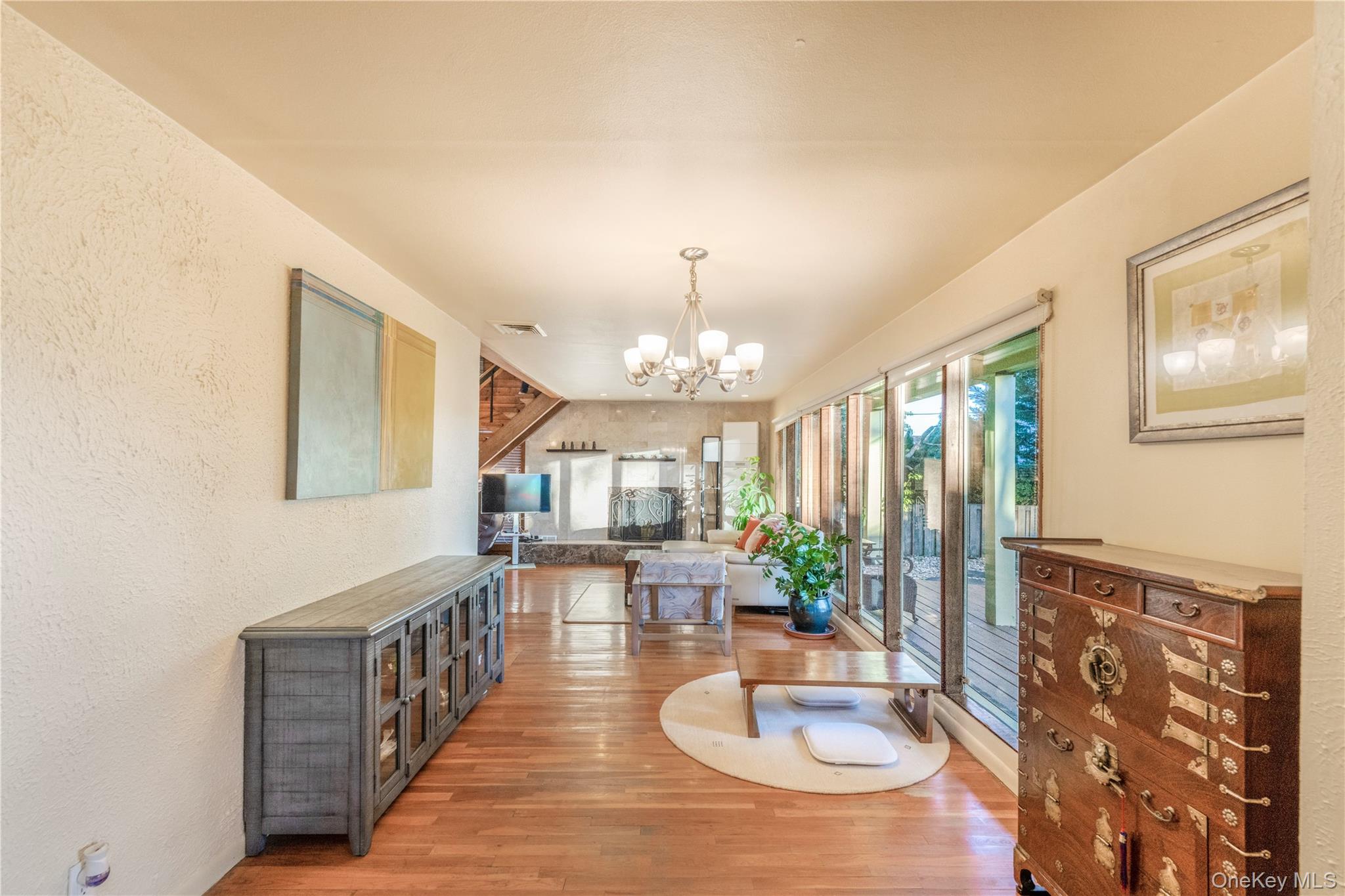 78 Joyce Road Plainview, NY 11803 - Photo 4 of 23 a dining room with furniture a chandelier and wooden floor