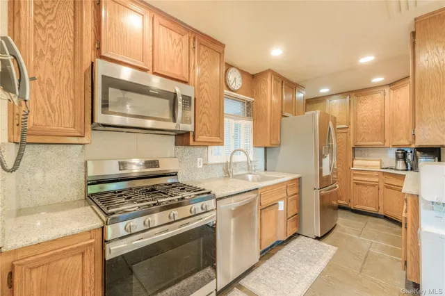a kitchen with stainless steel appliances a stove a sink and a refrigerator