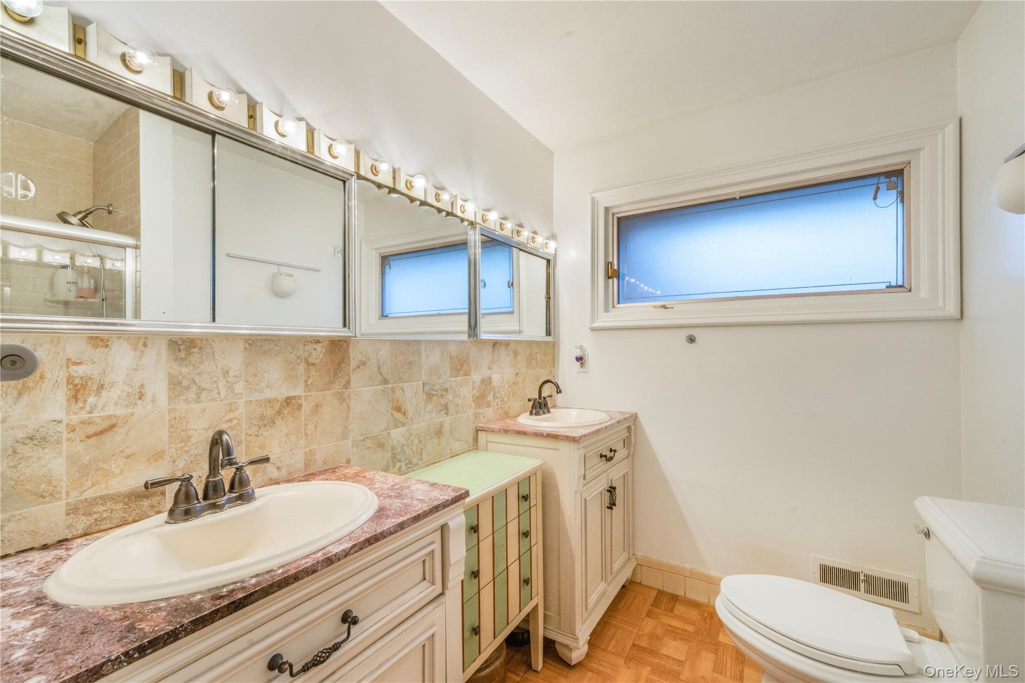 78 Joyce Road Plainview, NY 11803 - Photo 9 of 23 a bathroom with a granite countertop sink mirror vanity and toilet