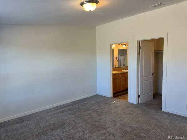 an empty room with closet and mirror