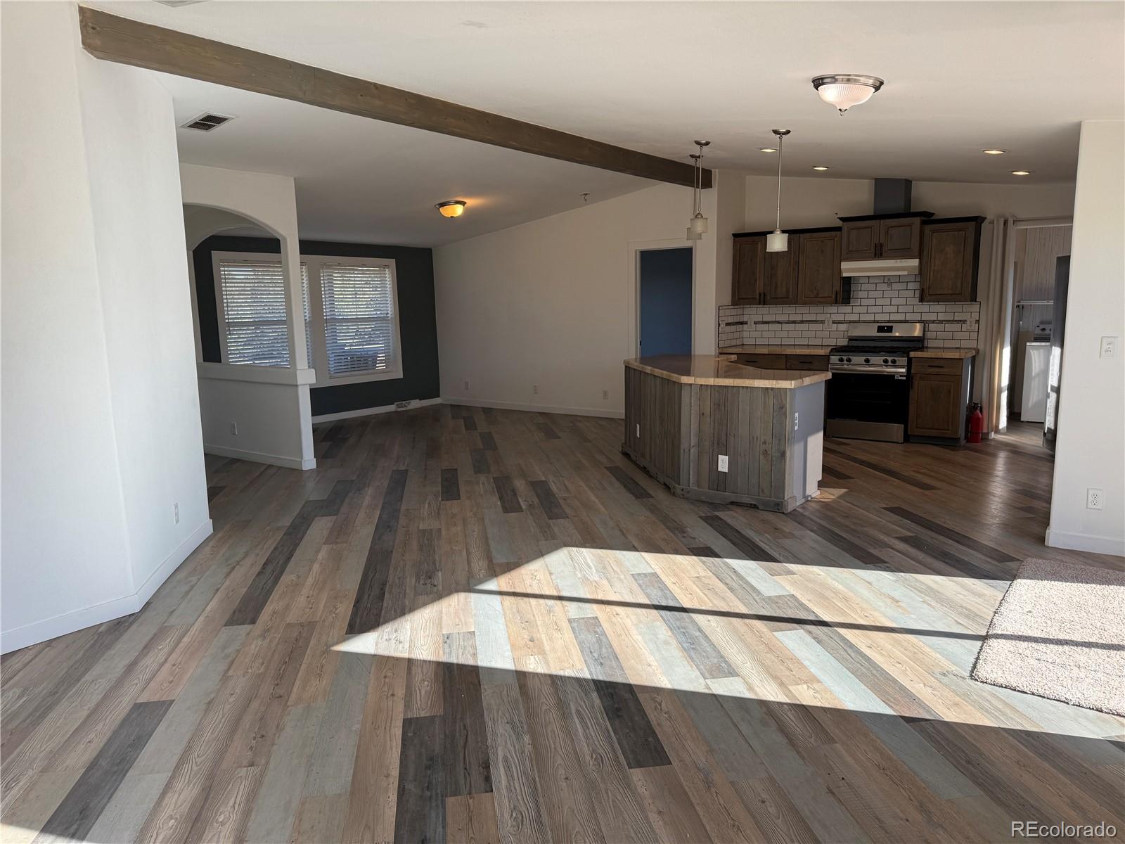 620 Falling Rock Road Cotopaxi, CO 81223 - Photo 10 of 32 a kitchen with stainless steel appliances kitchen island granite countertop a stove a refrigerator and a view of living room