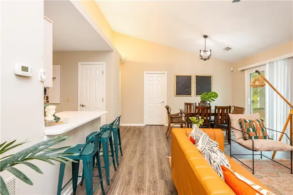a view of a dining room and livingroom with furniture wooden floor a chandelier