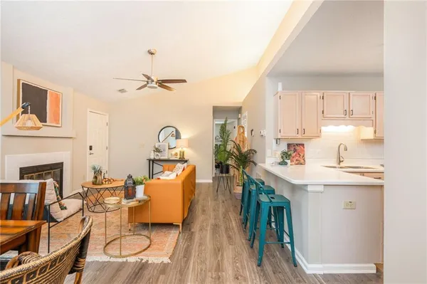 a very nice looking kitchen with a sink a microwave a dining table and chairs with wooden floor