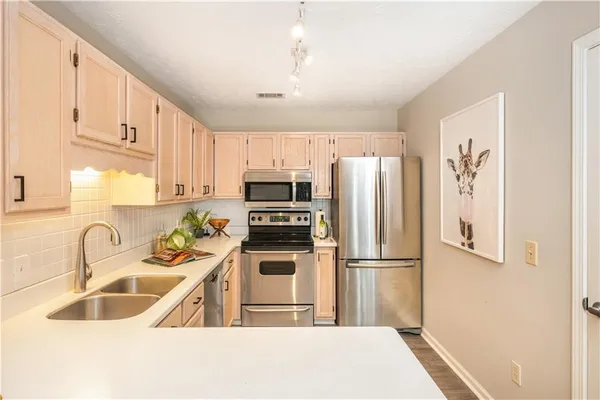 a kitchen with stainless steel appliances granite countertop a refrigerator sink and microwave