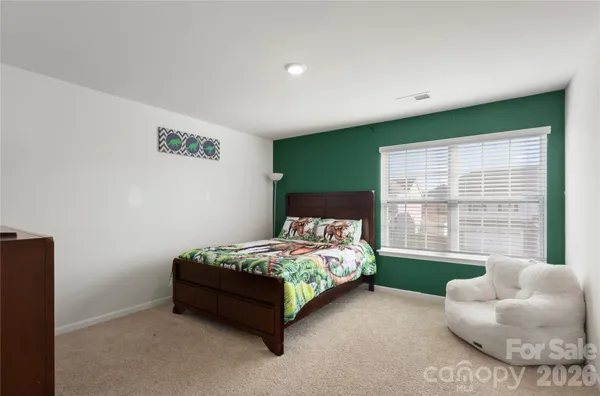 a bedroom with a bed and a flat tv screen on the dresser