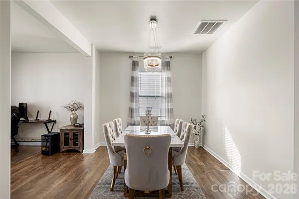 a dining room with furniture a chandelier and wooden floor