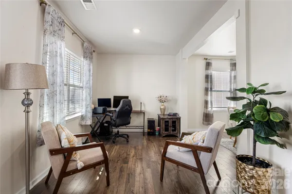 a living room with furniture a potted plant and a window