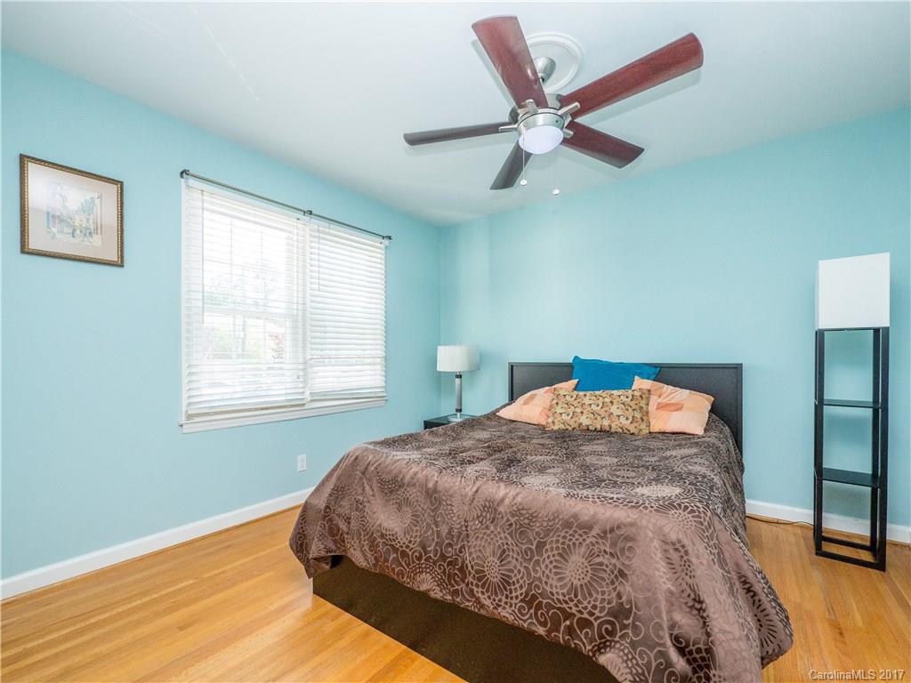 910 McAlway Road, Unit E Charlotte, NC 28211 - Photo 12 of 13 a bed sitting in a bedroom next to a window