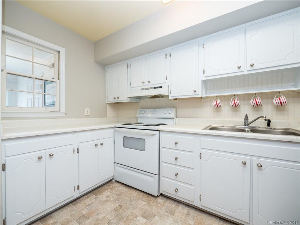 910 McAlway Road, Unit E Charlotte, NC 28211 - Photo 8 of 13 a kitchen with white cabinets white stainless steel appliances and sink