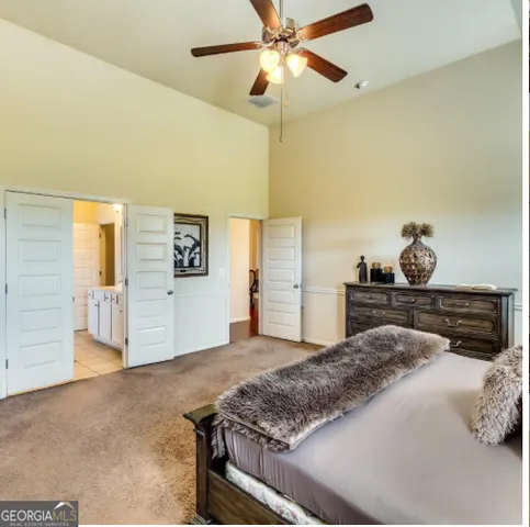 a bedroom with a large bed and a chandelier