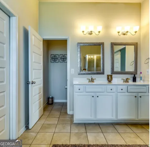 a spacious bathroom with a double vanity sink and a mirror