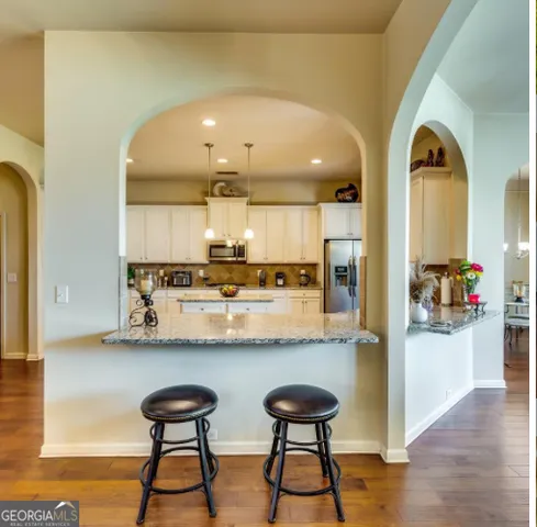 a kitchen with stainless steel appliances kitchen island a table and chairs in it