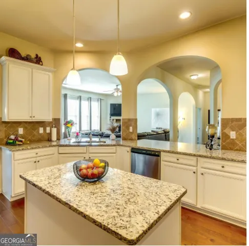 a view of a kitchen island a chandelier and wooden floor