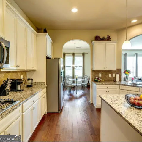 a large kitchen with a lot of counter space and wooden floor