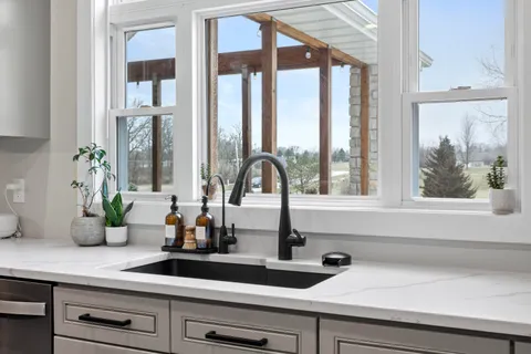 a kitchen with a dining table chairs sink and cabinets